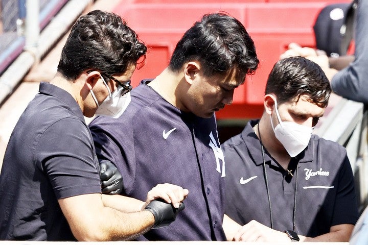 スタッフに抱えながら球場を後にした田中は、検査で無事を報告した。(C)Getty Images