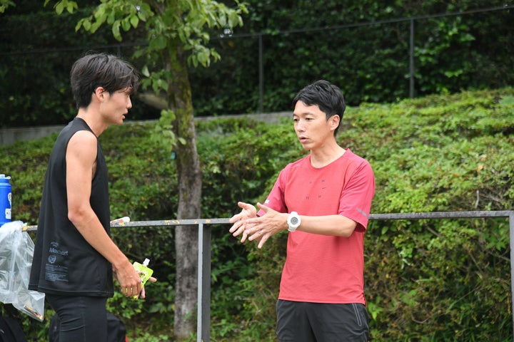 選手を指導する藤原監督（右）。今季は全日本大学駅伝で８位以内、箱根駅伝で５位以内を目指す。写真：徳原隆元