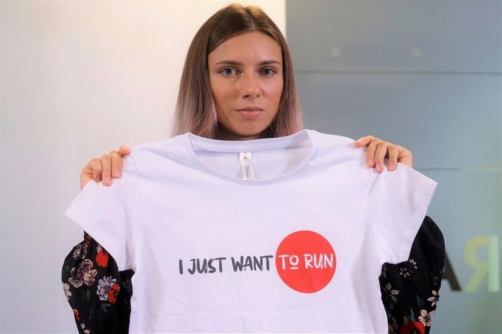日の丸デザインのTシャツに「私はただ走りたいだけ」とのメッセージを添えたツィマノウスカヤ。ワルシャワでの会見では笑顔も見られた。(C)AFLO