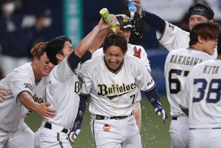 劇的なサヨナラ２ラン本塁打を放ったオリックスの吉田正尚（中）はチームメイトから手荒い祝福を受けた。写真：鈴木颯太朗