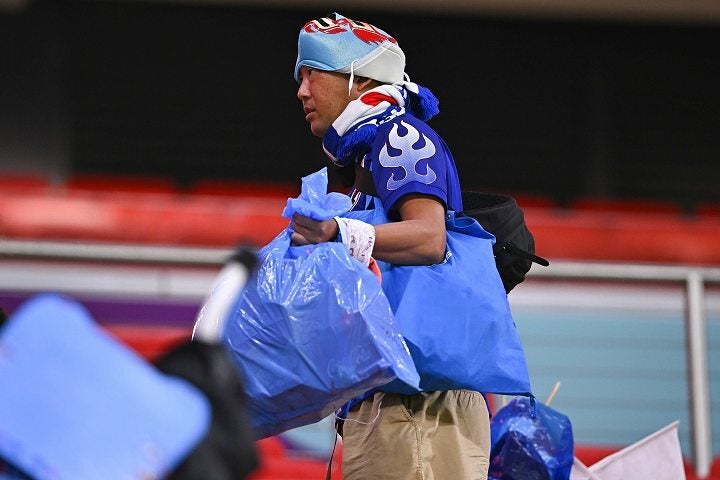 スタジアムのごみ拾いをする日本人のサポーター。海外メディアも彼らの変わらぬ精神に敬意を表している。写真：金子拓弥（THE DIGEST写真部／JMPA代表撮影）