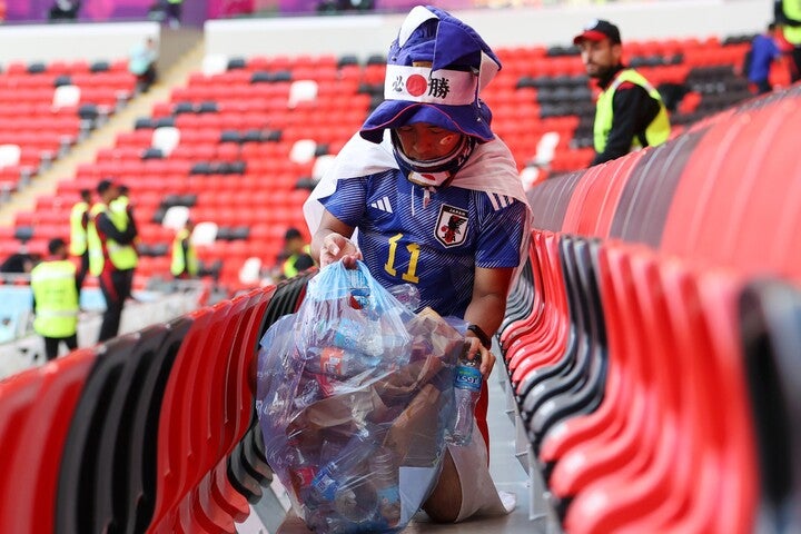 自分たちが落としたゴミを拾い集め、スタジアムを清掃する日本人サポーターたち。その行動が皮肉った動画に怒りの声が上がった。(C)Getty Images