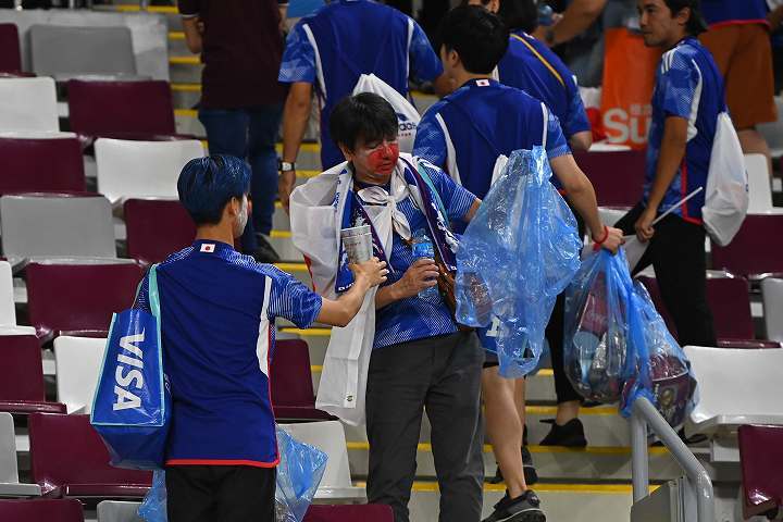 試合後にスタジアムのゴミ拾いをする日本人サポーターたち。写真：金子拓弥（THE DIGEST写真部／JMPA代表撮影）