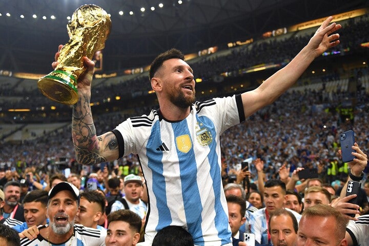 黄金に光り輝くワールドカップを手にし、笑顔を浮かべるメッシ。長く重責を担ってきたエースはようやく報われた。(C)Getty Images
