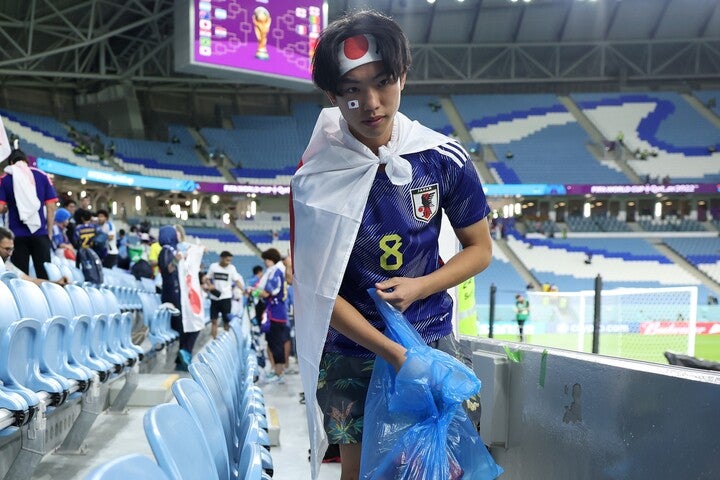 試合後に率先してゴミを拾った日本人サポーターたち。彼らが起こした“一大ムーブメント”は、いまだ賛辞を集め続けている。(C)Getty Images
