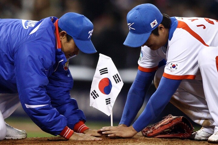 2009年の日韓戦勝利後にマウンドに国旗を埋める韓国の選手たち。このシーンは、当時の日本代表の面々を怒らせ、大きな波紋を広げた。(C)Getty Images