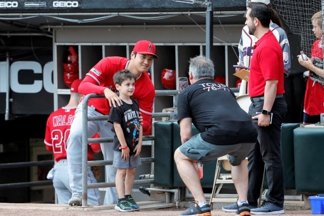 男の子の肩にそっと手を添える大谷。「まさに神の手だ」と評するファンも。(C)REUTERS/AFLO