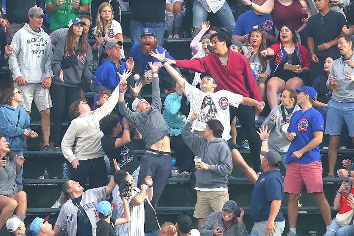 スタンドに飛び込んできたボールに必死に手を伸ばす野球ファン。スタジアム観戦の醍醐味だ。(C)Getty Images