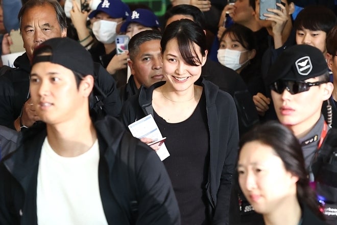 韓国に到着した大谷夫妻。大きな歓声が上がるなか、奥さんも笑顔で歩を進めた。(C)YONHAP NEWS/AFLO