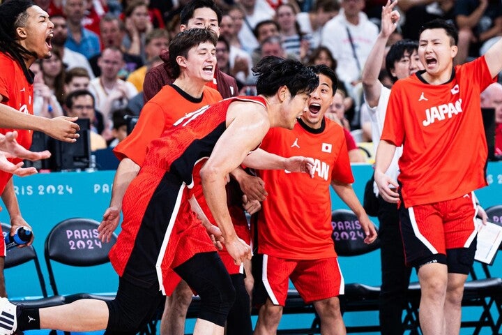 吉井のシュートに沸く日本ベンチ陣。世界王者ドイツに対し、終盤まで食い下がってみせた。(C)FIBA