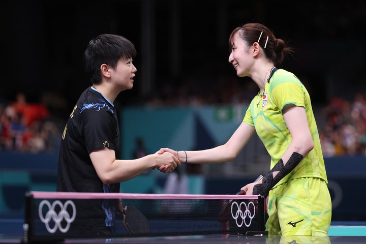 笑顔で握手を交わす早田ひな（右）と孫穎莎（左）。(C) Getty Images