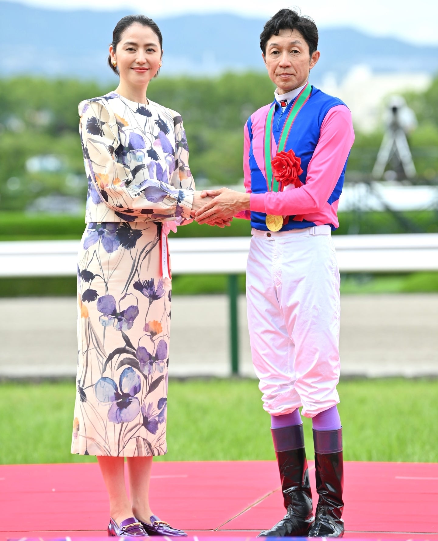 握手を交わす長澤まさみさん（左）と優勝ジョッキーの武豊騎手（右）。スタイリッシュな両者の豪華ショットだ。写真：産経新聞社