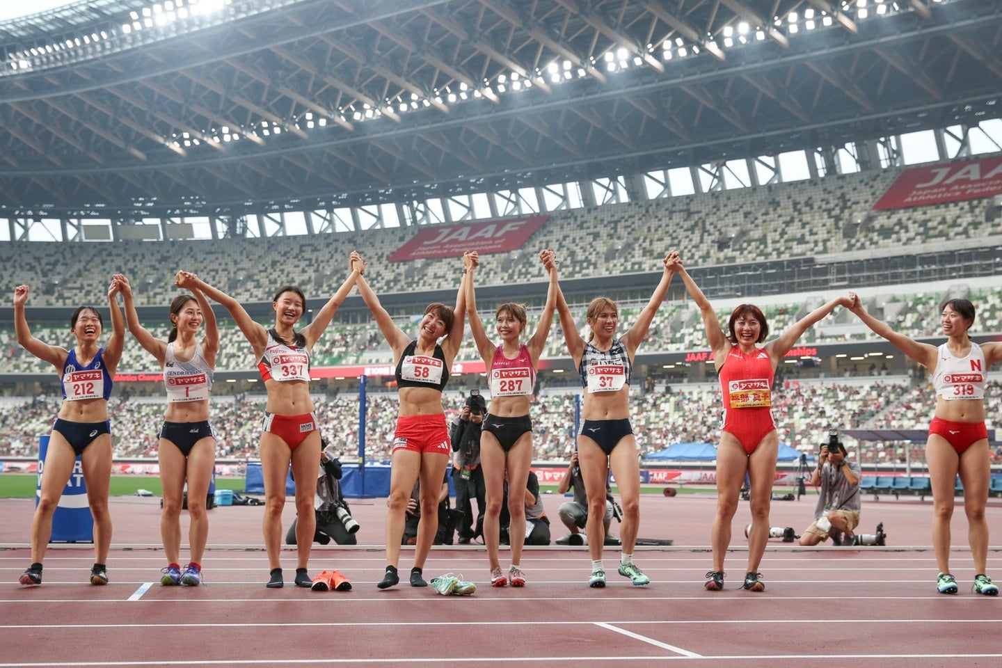 順位が確定し、選手たちは手をつないで観客の声援に応えた。写真：永島裕基