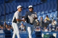 対戦後に握手で健闘を称え合う五十嵐氏（左）と里崎氏（右）。写真：萩原孝弘