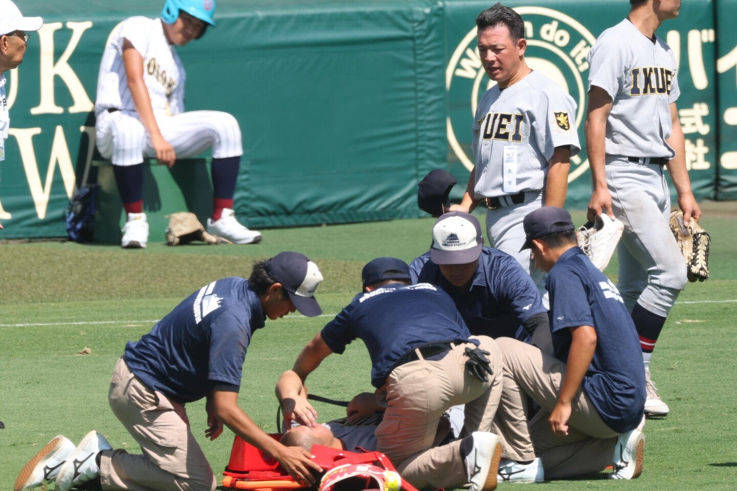 担架で運ばれようとする田山を見守る須江監督。対策していても甲子園の暑さはかなりのものだ。　写真：産経新聞社