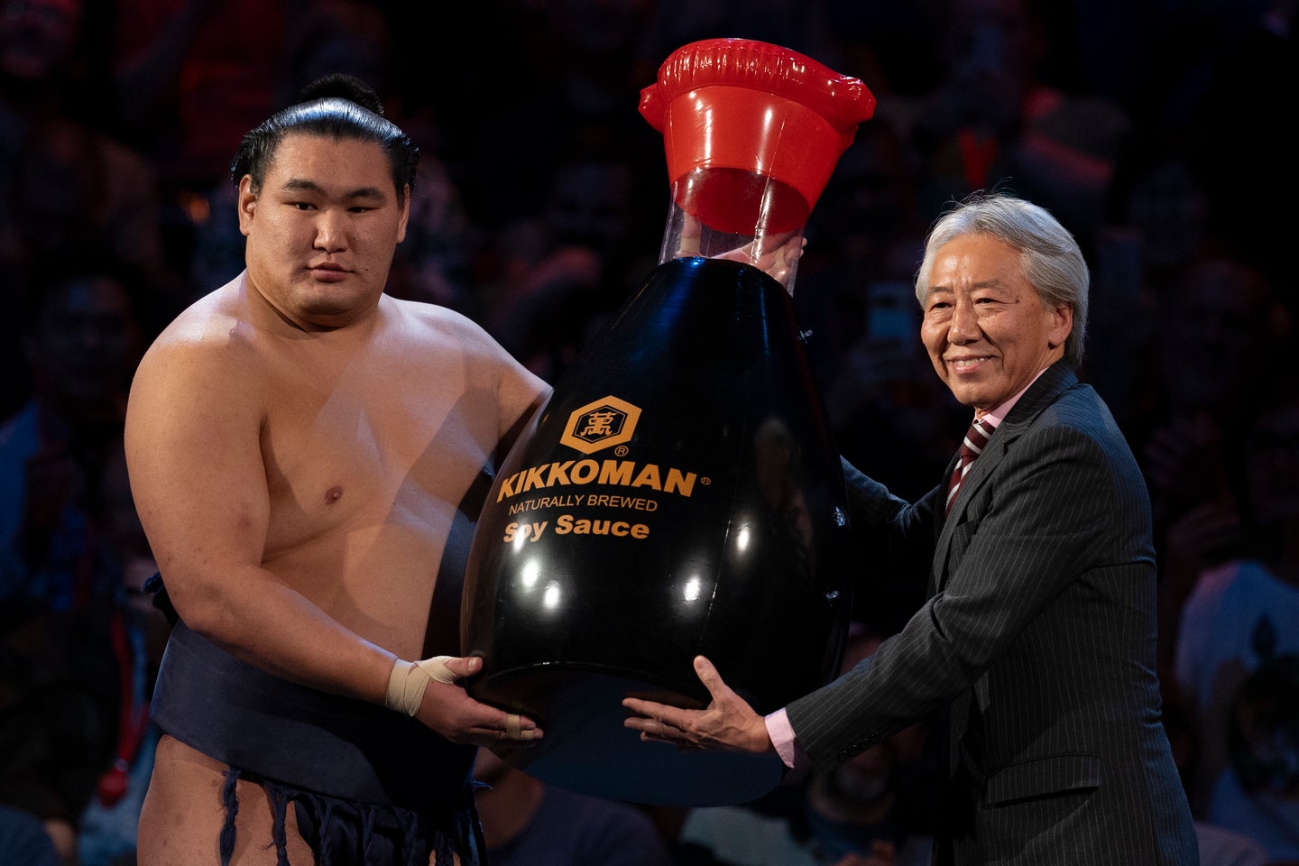 ５戦全勝で優勝を飾った横綱・豊昇龍（左）。副賞として巨大なキッコーマンのしょうゆボトルを受け取った。(C) Getty Images