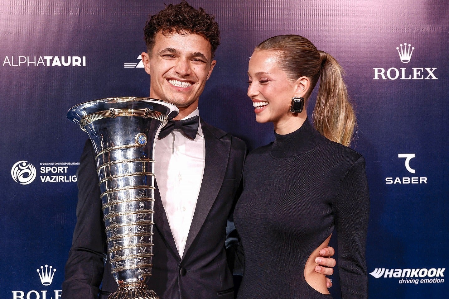 トロフィーを手に笑顔を浮かべるノリス（左）とパートナーのコルセイロさん（右）。(C)Getty Images