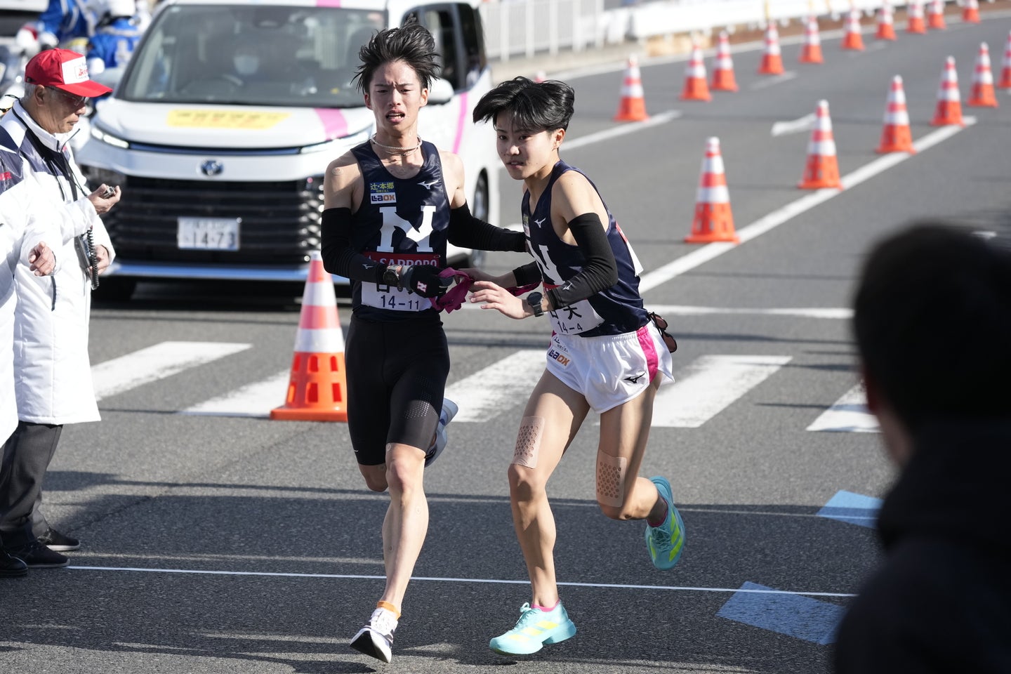 ４区の片桐（右）へ襷を繋いだ、３区・冨田（左）の姿。写真：JMPA