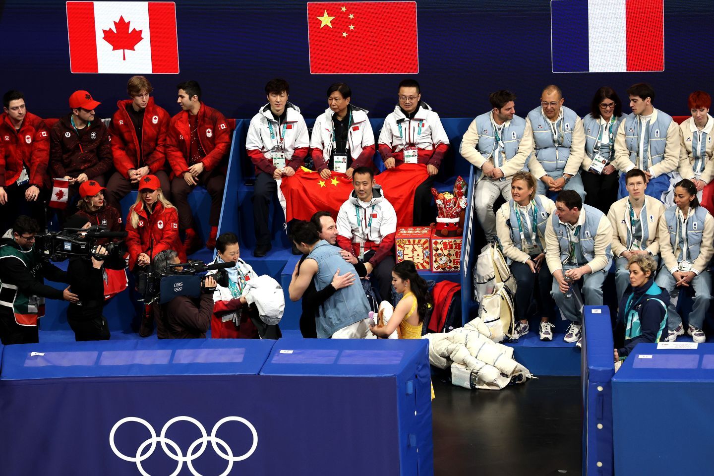 フィギュア団体の各国ブース。中国代表（中央）もアイスダンスの頃はみんなで声援を送っていたが…。(C)Getty Images