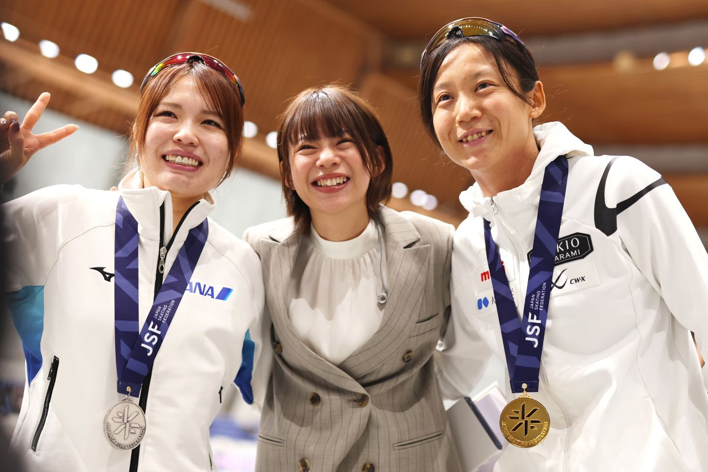 佐藤綾乃（左）＆妹・高木美帆（右）と記念撮影に収まる髙木菜那さん。現地解説が分かりやすいと好評だ。写真：森田直樹/アフロスポーツ
