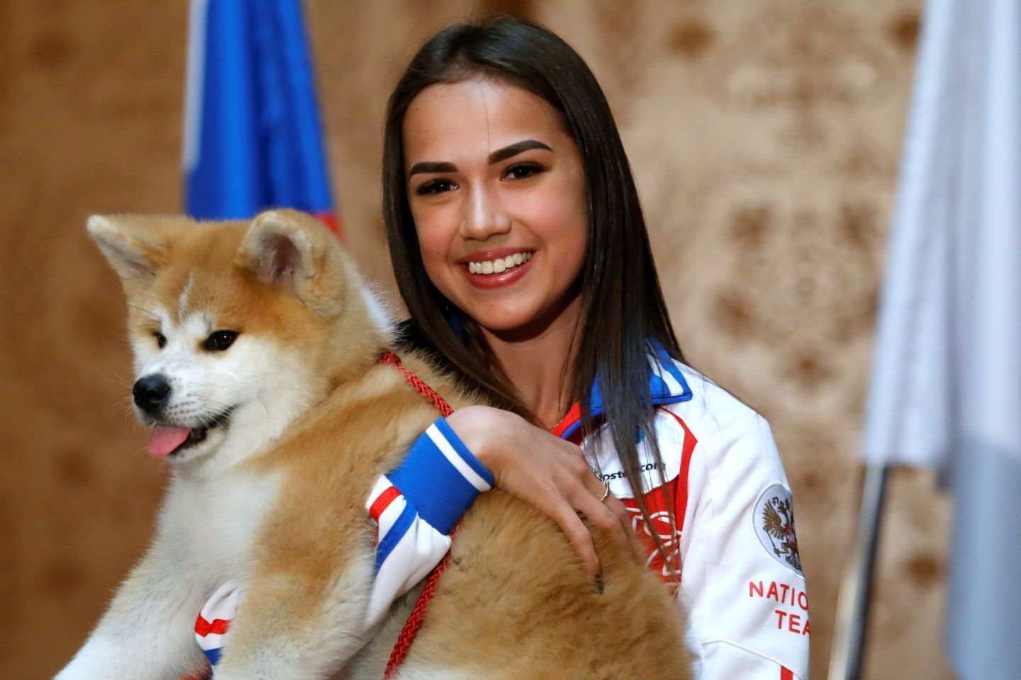 今から８年前、メスの秋田犬（マサル）を贈られて満面の笑みを浮かべるザギトワ。五輪女王は当時15歳だった。(C)REUTERS/AFLO