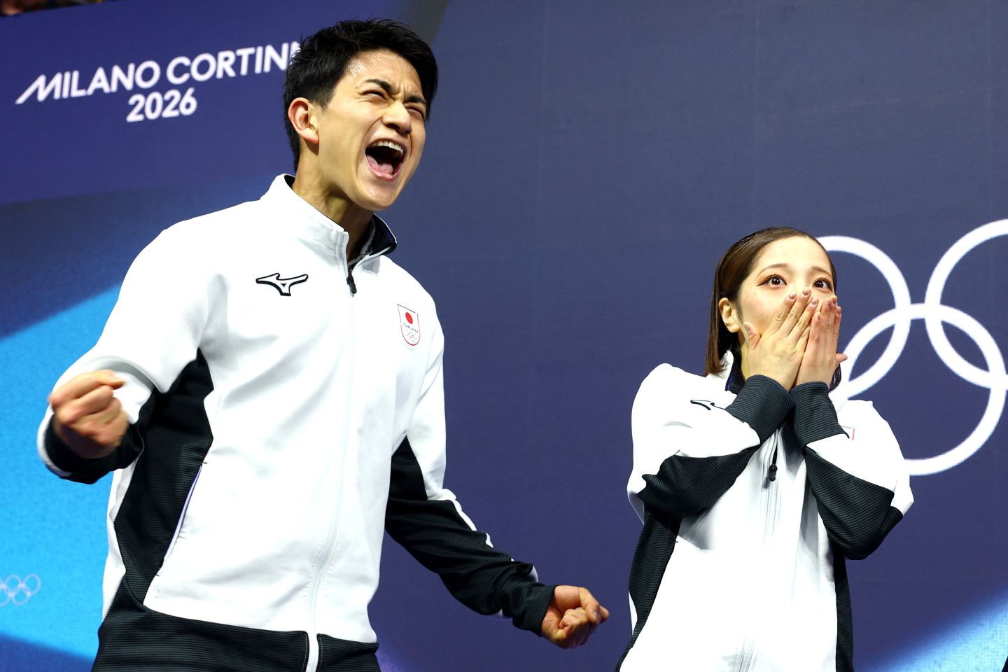 世界最高得点を叩き出して絶叫する木原（左）と絶句する三浦。“りくりゅう”が五輪で頂点に立った。(C)REUTERS/AFLO