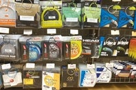 テニスショップに数多く並ぶポリエステル系ストリング。ポリだからこそ実現した「多角形断面」は４～10角形断面まで見られる。写真提供：松尾高司