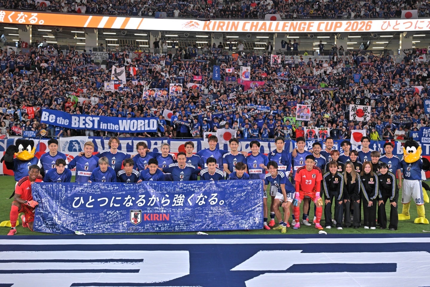 サポーターを背にして記念撮影する日本代表。写真：金子拓弥（THE DIGEST写真部）