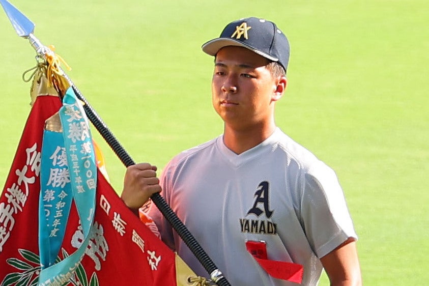 青森大会の優勝旗を手に、先頭で入場行進する青森山田の須藤彪（ひゅう）主将（３年）。写真：梅月智史（THE DIGEST写真部）